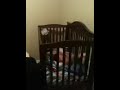 Funny baby climbing out and jumping into his crib