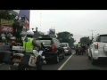 2 Indonesian police motorcycles escorting a convoy of cars - 1