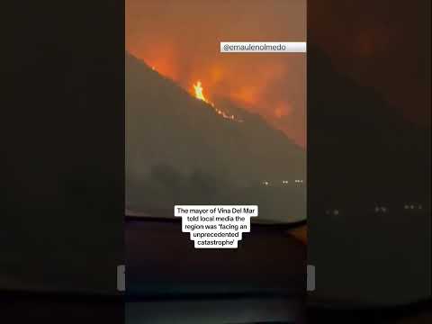 Cars drive past terrifying wildfire in Chile