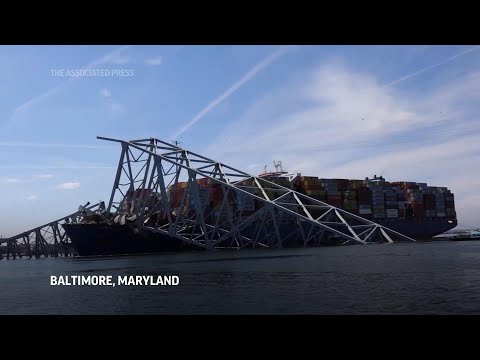 View of cargo ship and collapsed Baltimore bridge from Coast Guard boat as recovery effort continues