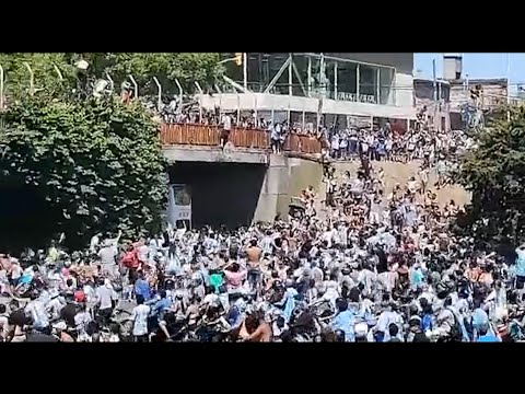 Dos aficionados se tiran desde un puente al autobús de la selección argentina