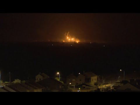 Flares and explosions over Gaza night sky as seen from across border in Israel