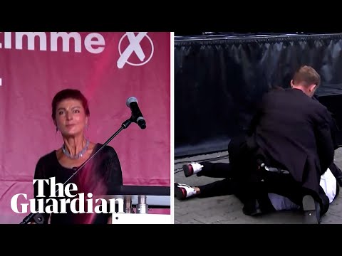 Moment German politician is sprayed with red liquid at a rally