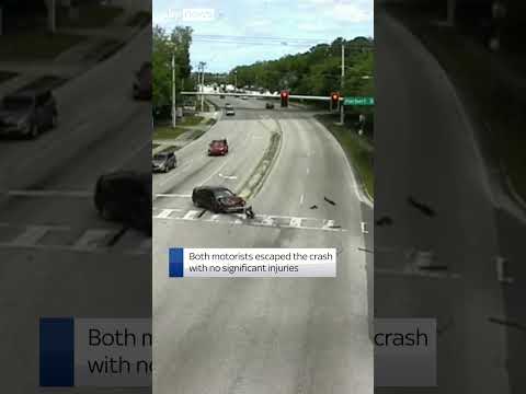 Moment drivers who both ran red lights collide