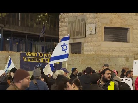 Protesters wave Israeli flags outside UNRWA offices in Jerusalem