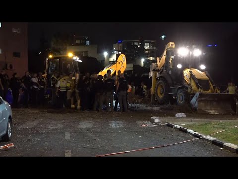 Security forces work in the area hit by a rocket in Haifa