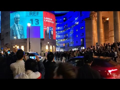 People cheer as exit polls projected onto BBC HQ show Labour landslide in UK election | AFP