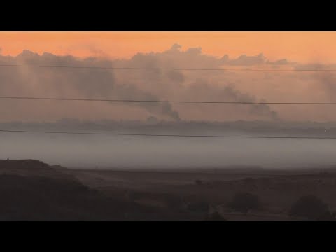 Smoke plumes on the horizon as sun sets over Gaza Strip