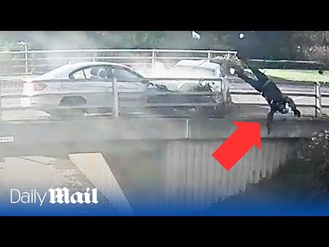 Horrifying moment biker is catapulted over the side of a bridge after being hit by road rage driver