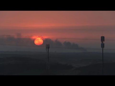 Smoke rises over Gaza as the sun sets on the horizon