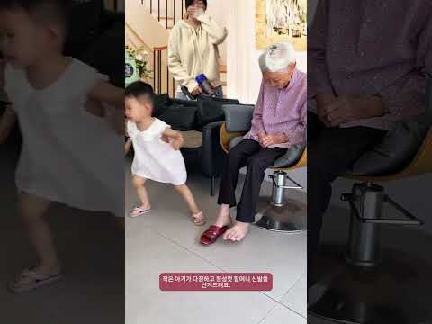 작은 아기가 다정하고 정성껏 할머니 <strong>신발을</strong> 신겨드려요.
