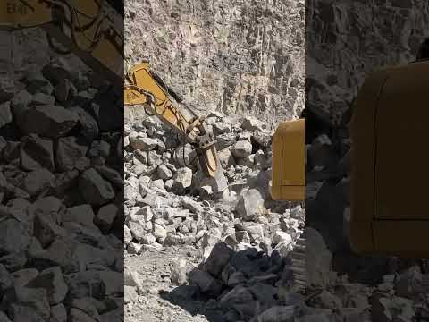 Excavadora picando piedra en banco de piedra caliza