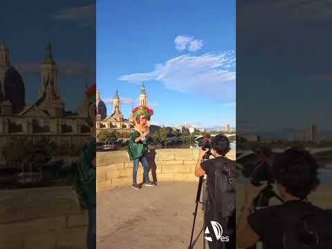 Cabezudo de Zaragoza haciéndose un selfie en el puente de Piedra con la Basílica del Pilar