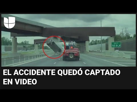 El momento en que un camión con remolque choca contra un paso elevado en una autopista