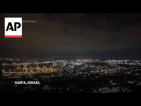 Security personnel clear rubble after sirens and blasts heard in Haifa, northern Israel