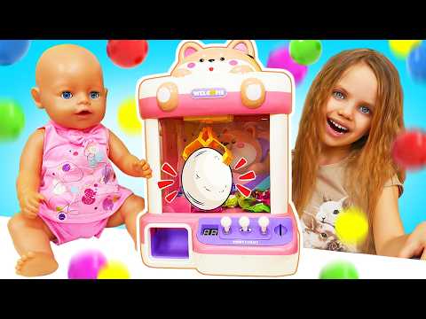 Maya is trying to get toys out of the claw machine and making toy food for her doll.