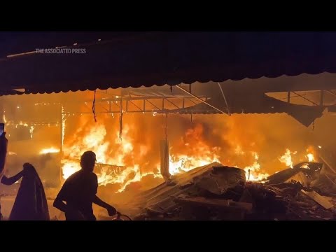 Desperate Palestinians try to extinguish a fire following strike near central Gaza hospital