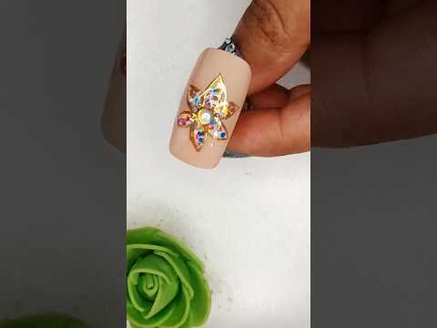 A dazzling flower nail art featuring multicolored rhinestones and golden detailing ✨️🌸 #naildesign