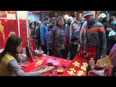 Taiwanese buy Dragon New Year couplets and flowers on the eve of Lunar New Year