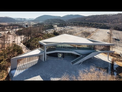 Moveable wooden screens are set into concrete facades of Mokyeonri Wood Culture Museum