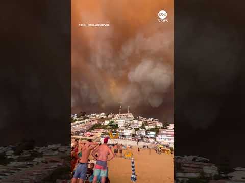 Beachgoers watched on as smoke from deadly wildfires filled the sky over a Chilean seaside town.