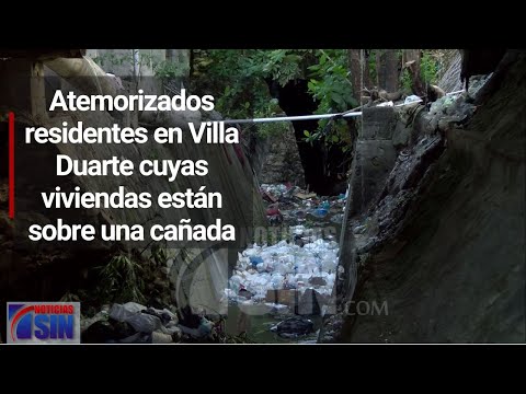 Atemorizados residentes en Villa Duarte cuyas viviendas están sobre una cañada