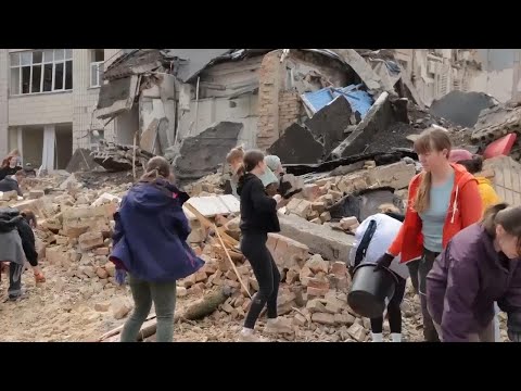 Volunteers in Kyiv help to clear rubble from streets after latest Russian missile strikes