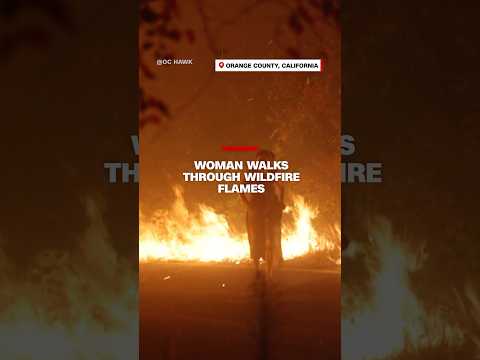 Woman walks through wildfire flames