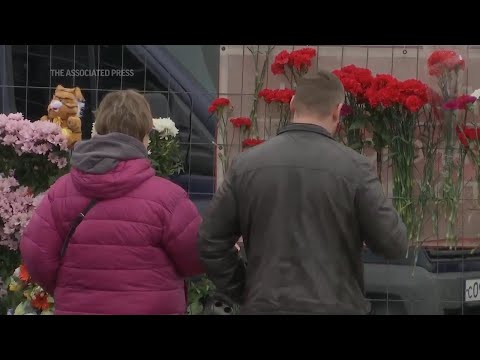 Mourners lay flowers for the victims at the site of terror attack in Moscow