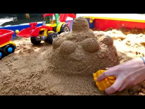 Toy cars make a sand cake at the sandbox