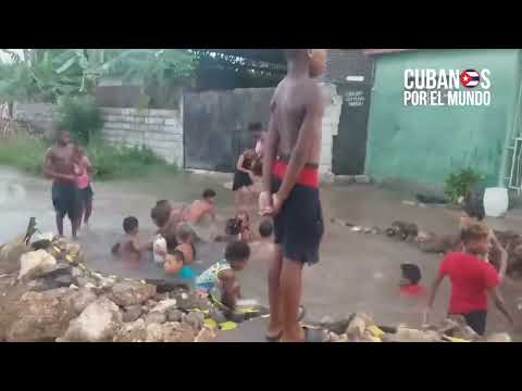 Niños cubanos usan bache gigante en Marianao como una piscina