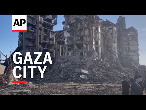 Palestinians walk among destroyed buildings in neighbourhoods in Gaza City, amid scenes of devastati