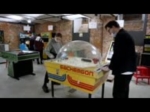 Visitors play retro arcade games at museum