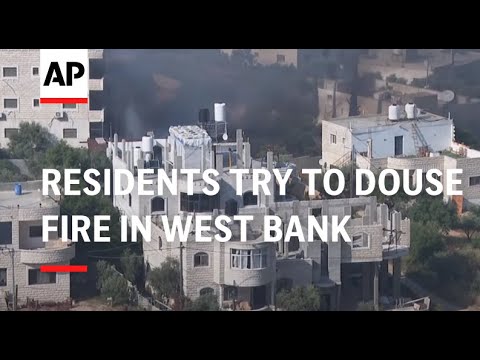Palestinian residents try to douse fire in West Bank village that was attacked by settlers