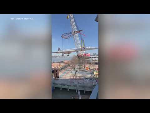 Concorde jet lifted by crane onto museum pier in Manhattan