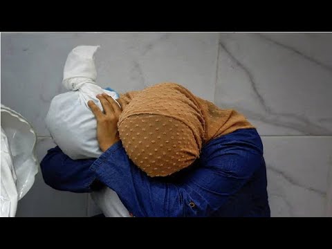 Una mujer abrazando a una niña que acaba de perder la vida en la Franja de Gaza