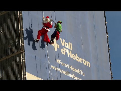 Papá Noel baja haciendo rapel por la fachada del Hospital Vall d'Hebron para visitar a los niño