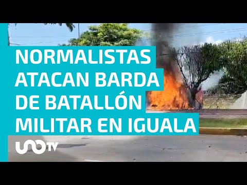 Normalistas de Ayotzinapa lanzan petardos y estrellan vehículo contra barda de la zona militar