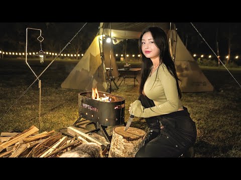 Girls solo camping. Building a tent on the lawn and grilling over a brazier.