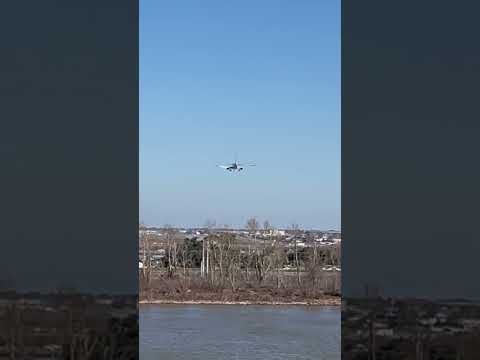 Flight landing at New Orleans airport observed from Mississippi River waters.