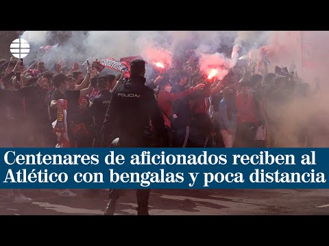 Varios centenares de aficionados reciben al Atlético con bengalas y poca distancia